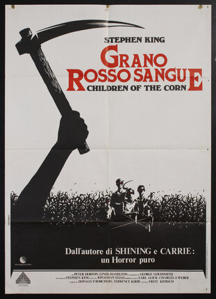 movie poster with a hand raising a scythe or sickle with a corn field and evil red-eyed children in the background.