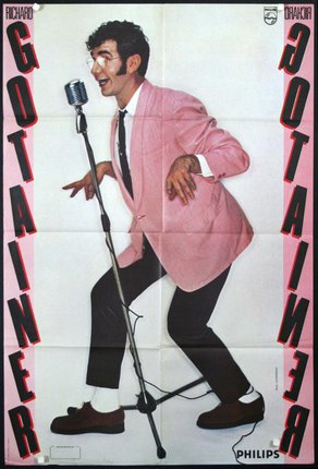 a man in a pink coat and black pants with a microphone