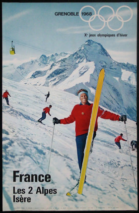 a woman holding a ski in front of a mountain