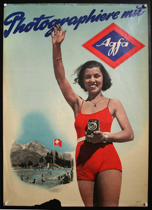 a woman in a red bathing suit holding a camera