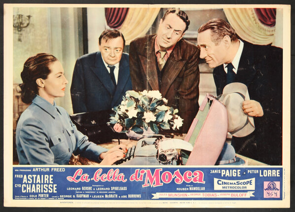 a movie poster of a woman sitting at a table with a suitcase and a woman looking at a woman