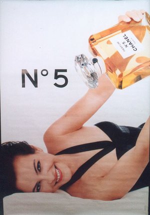 a woman holding a bottle of perfume