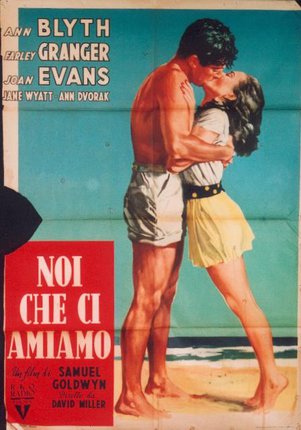 a man and woman kissing on a beach