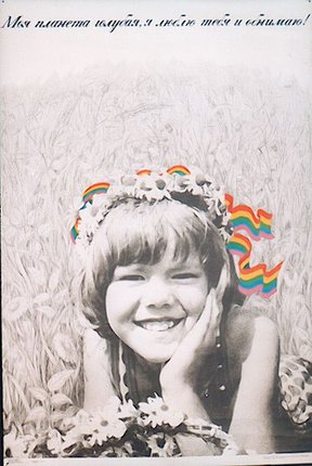 a child smiling with rainbow ribbon on her head