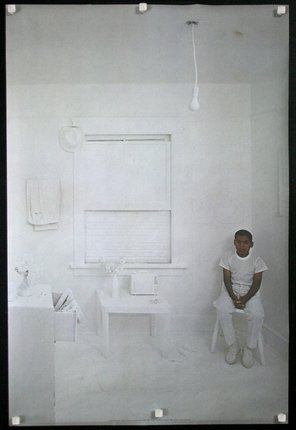a man sitting in a white room