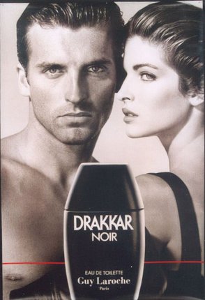 a man and woman holding a bottle of perfume