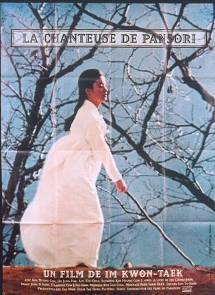 a woman in a white dress walking on a tree branch
