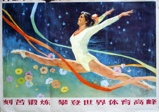 a woman in a leotard jumping in the air with ribbons
