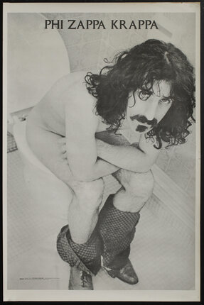 a man with long hair and mustache sitting on a toilet