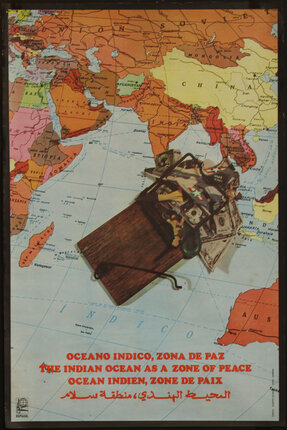 A wooden mouse trap with money, missiles, and jets in it sits on top of a map of the Middle East and Asia.