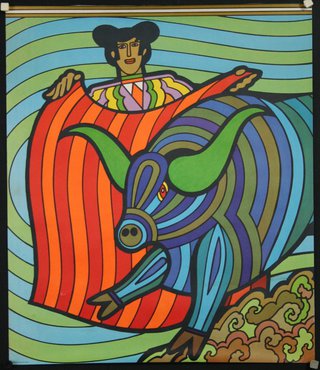 a colorful bull with a man holding a blanket