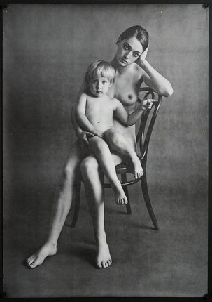 a woman sitting on a chair holding a baby