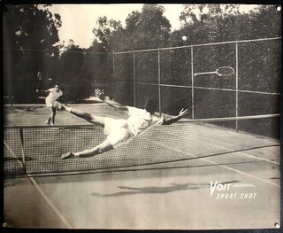 a man hitting a tennis ball with another man