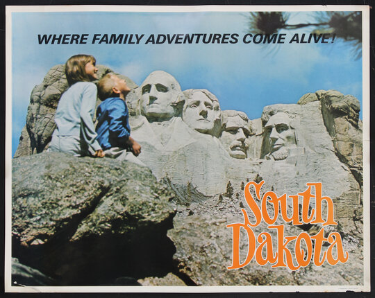 two kids looking at a the stone faces of Mount Rushmore