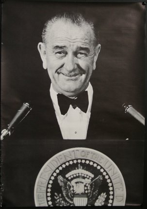 a man in a bow tie at a podium