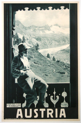 a man sitting on a window sill looking out a mountain range