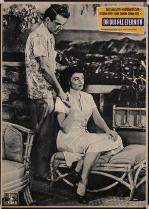 a man standing next to a woman sitting on a chair