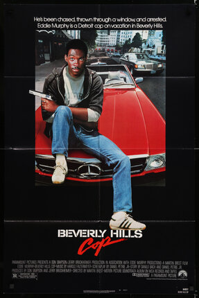 a movie poster of a man sitting on a red car with a gun