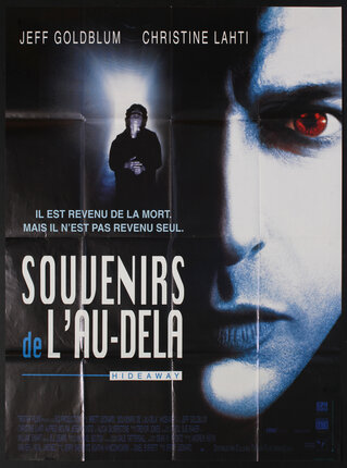 a movie poster with a man's face and someone coming through a lit up corridor.