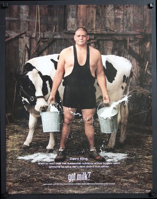a man holding buckets of milk