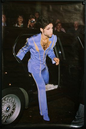 a man in blue suit coming out of a car