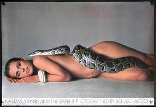 a woman lying on the floor with a snake around her body