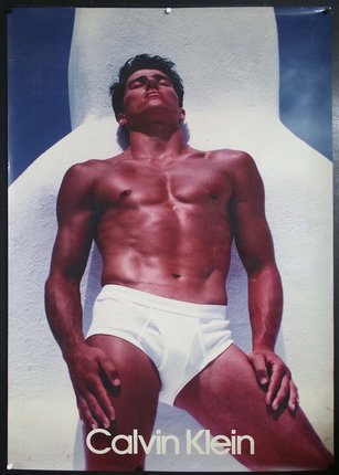 a man in underwear lying on a white wall