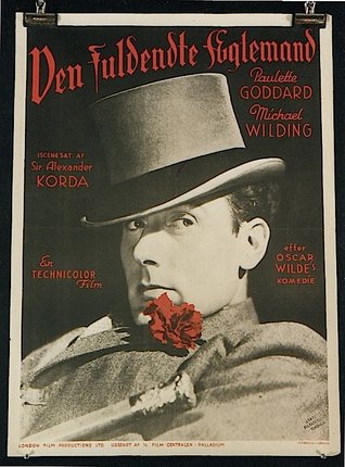 a man wearing a hat and holding a flower