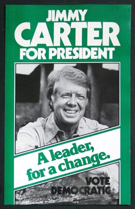 a man smiling in a green and white sign