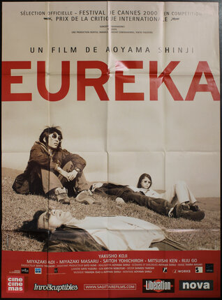 a movie poster with a group of people lying on the grass