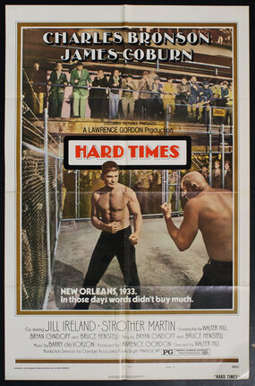movie poster with two boxers in an iron-fenced concrete-ground fighting pen with spectators looking on from above.