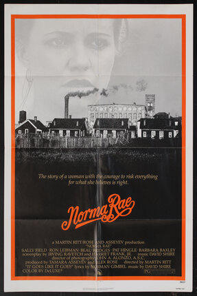 movie poster with a pointillist rendering of a village of houses with  industrial buildings in the background and a woman's face in the sky