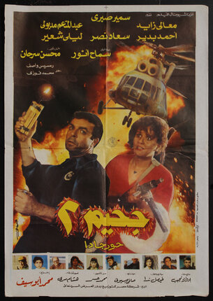 Movie poster with a man holding dynamite, a woman holding a machine gun, and a helicopter flying in front of an explosion