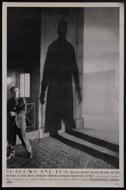 a man standing next to a looming shadow of another man on the wall beside him