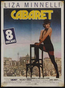 movie poster of a woman in a bowler hat, vest and shorts and thigh-high stockings posing with her foot on a chair. A Nazi rally is in the background.